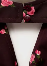 Top halter marrón con estampado de rosas rosadas, espalda descubierta y cierre de lazo en el cuello. Diseño entallado.