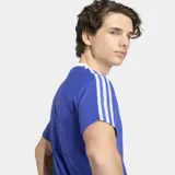 Remera de algodón y poliéster color azul, con cuello redondo blanco, mangas cortas con las tres tiras características de la marca en blanco, logo del trifolio y escudo de la AFA en el frente.