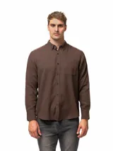 Camisa de franela de manga larga color marrón, con cuello abotonado, cierre frontal de botones y un bolsillo aplicado en el pecho.