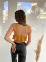 Top corto mostaza con breteles finos, escote en V y volados en el ruedo.