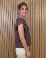 Musculosa de lino color marrón con mangas con volantes y cuello redondo.