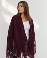 Ruana de lana merino tejida en punto texturizado, color bordó, con flecos en el borde inferior.