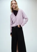 Cardigan de punto con cuello en pico y cierre frontal de botones. Presenta un diseño recto de manga larga con puños en contraste.