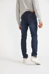 Jean de hombre color gris oscuro, corte recto, con roturas y logo bordado.