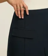 Short pollera de cintura alta color azul marino, confeccionado en tejido plano. Presenta solapas delanteras simulando bolsillos y un recorte en V en el ruedo.