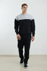 Sweater deportivo de hombre con escote redondo, diseño colorblock con la parte superior en gris claro y el cuerpo y mangas en negro. Presenta puños y cintura elastizados.