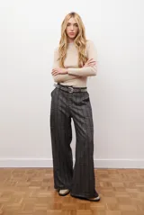 Pantalón de corte sastrero y pierna ancha con estampado de cuadros tipo príncipe de gales. Presenta un diseño de tiro alto y caída fluida.