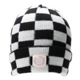 Gorro tipo beanie tejido con diseño de damero en blanco y negro. Presenta un parche rectangular en el frente con la frase 'Expect Only All Good Things' estampada en color rosado.