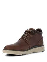 Botín Hush Puppies modelo William, confeccionado en cuero marrón con cordones bicolor. Presenta un diseño de caña media con cuello acolchado y suela de EVA en tono beige con base dentada.