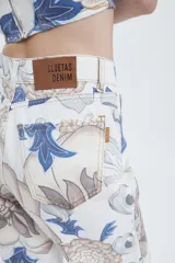Pantalón de tiro alto y piernas amplias, confeccionado en gabardina de algodón estampada con diseño floral en tonos azul, beige y marrón.