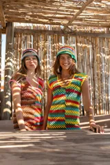 Vestido corto tejido a crochet con diseño de bloques de colores vibrantes, escote redondo y mangas cortas.