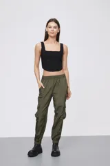 Babucha estilo cargo color verde oliva, confeccionada en tela técnica con acabado satinado. Presenta cintura elástica, bolsillos laterales con solapa y puños elásticos en los tobillos.