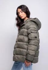 Campera puffer de nylon color negro con capucha, cierre frontal y bolsillos laterales. Presenta un bolsillo adicional con solapa en la manga izquierda y puños elásticos.