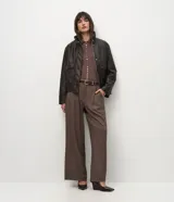 Campera de cuero sintético marrón con efecto desteñido, cuello alto y solapa de piel sintética desmontable. Cuenta con cierre frontal, bolsillos delanteros con solapa y elástico en el ruedo.