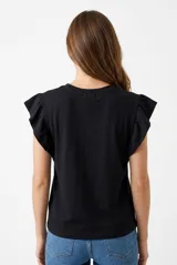 Remera color beige con cuello redondo y mangas cortas adornadas con volados fruncidos.