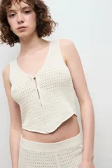 Chaleco negro de punto con escote en V y cierre frontal con dos ganchos metálicos.