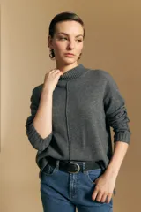 Polera de tejido de punto color blanco, con cuello alto acanalado, hombros caídos y detalle de costura vertical en el frente.