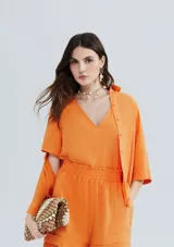 Blusa naranja de lino con escote en V y mangas cortas.