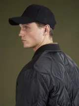 Campera acolchada verde militar con cuello mao, cierre frontal con botones a presión y bolsillos laterales.