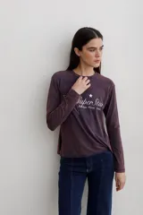 Remera de manga larga con efecto lavado, cuello redondo y estampa frontal con diseño de estrella y texto.