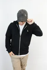 Campera negra con capucha y cierre frontal, confeccionada en algodón fino de punto.