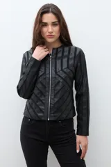 Chaqueta negra de eco cuero con cierre frontal y cuello redondo. Presenta paneles con diseño geométrico de tiras en relieve en el frente y mangas.