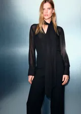Mono largo de fiesta con diseño combinado, cuerpo de tejido semitransparente con textura de puntos y pantalón de corte recto. Presenta cuello en pico, mangas largas con puños abotonados, cierre frontal de cremallera y botones, y detalle de fular integrado en el cuello con aplicaciones de strass.