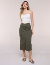 Falda midi estilo cargo color verde militar, confeccionada en gabardina de algodón. Presenta tiro alto, silueta recta, bolsillos laterales tipo cargo, bolsillos frontales y traseros, además de una costura central con tajo inferior en el frente.
