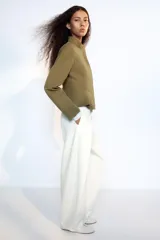 Cazadora entallada Zara color verde militar, con cuello alto, manga larga y bajo acabado en peplum. Cuenta con cierre frontal oculto con cremallera y botones a presión.