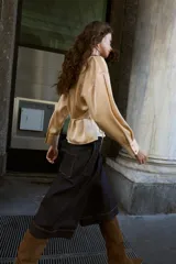 Camisa de manga larga color beige claro, con cuello solapa, escote pico y detalle de cinturón fino a tono que se anuda en la cintura.