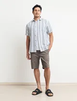 Camisa de manga corta a rayas verticales color natural y azul, con cuello clásico y cierre frontal con botones.