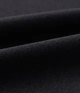 Pantalón de corte fluido y estilo pijama, color negro, con cintura elástica ajustable mediante lazo y detalle de tiras con hebilla en los tobillos.