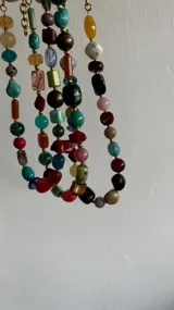 Collar corto con cuentas de colores y cadena de ajuste.