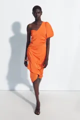 Vestido midi asimétrico de satén color naranja, con una sola manga corta abullonada, diseño drapeado en el lateral y falda cruzada.