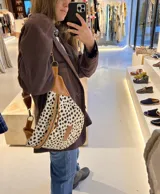 Riñonera con estampado animal, con detalles en cuero color chocolate y correa regulable.