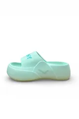 Chancletas blancas de plataforma con faja ancha y suela de goma. Tienen detalles en color salmón en la faja y suela tostada.
