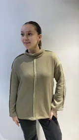 Buzo tejido color verde oliva, de corte holgado y cuello alto.