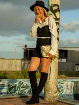 Crop top negro con broches frontales, sin mangas y confeccionado en tul.