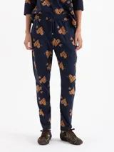 Babucha de tejido flammé color azul marino con estampado de corazones con textura animal print y flechas. Presenta cintura elastizada con cordón de ajuste y corte holgado.