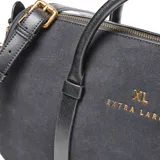 Cartera tipo baúl compacta de símil gamuza color negro, combinada con detalles de PU liso. Cuenta con doble asa corta rígida, correa larga regulable y desmontable, y herrajes metálicos dorados. El compartimento principal tiene cierre superior y un bolsillo interno con cierre. Detalle frontal con logo XL metalizado.