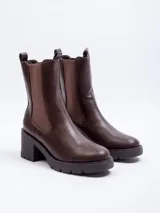 Bota tipo Chelsea de caña alta, confeccionada en cuero sintético negro, con paneles elásticos laterales y suela track con plataforma.