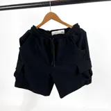 Bermuda negra de algodón fino con textura waffle, corte recto y bolsillos cargo laterales.