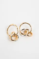 Aros colgantes compuestos por un aro principal texturizado en tono dorado de donde cuelgan argollas entrelazadas en tonos dorado y plateado.