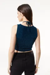 Top elastizado de lurex azul con aberturas en el frente, escote pronunciado y ajuste en el cuello.