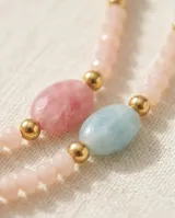 Collar de acero con baño de oro, compuesto por pequeñas cuentas de piedras naturales en tonos pastel y detalles metálicos dorados.