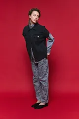 Chaleco de jean oversized color negro, con cuello camisero y cierre frontal con botones metálicos. Presenta un diseño estructurado con costuras reforzadas.