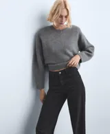 Pantalón de jean negro de corte recto y tiro alto, con diseño clásico de cinco bolsillos y cierre frontal con botón y cremallera.