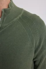 Cardigan azul de tejido de punto con cierre frontal y cuello alto.