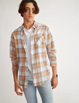 Camisa de manga larga a cuadros amarillos, blancos y grises, con bolsillo en el pecho y botones de pasta.