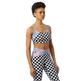 Top deportivo New Balance con estampado a cuadros blancos y negros, tirantes finos celestes y detalles iridiscentes en los laterales.